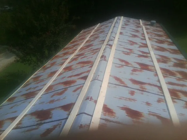 Rusted metal roof panels with new wood purlins before replacement — Storm Damage Roof Repair in Patton by Roofing Brothers