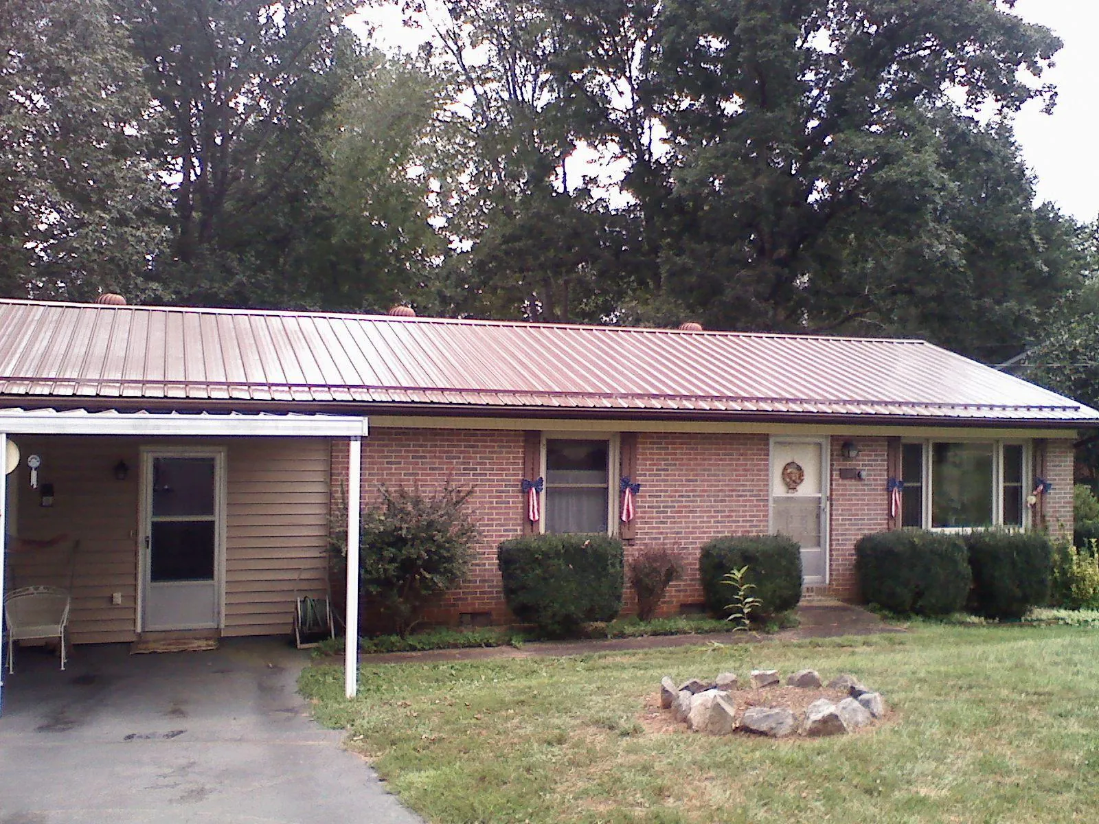 Bronze metal roof and carport on a brick ranch home — Roof Repair work by our crew in Patton